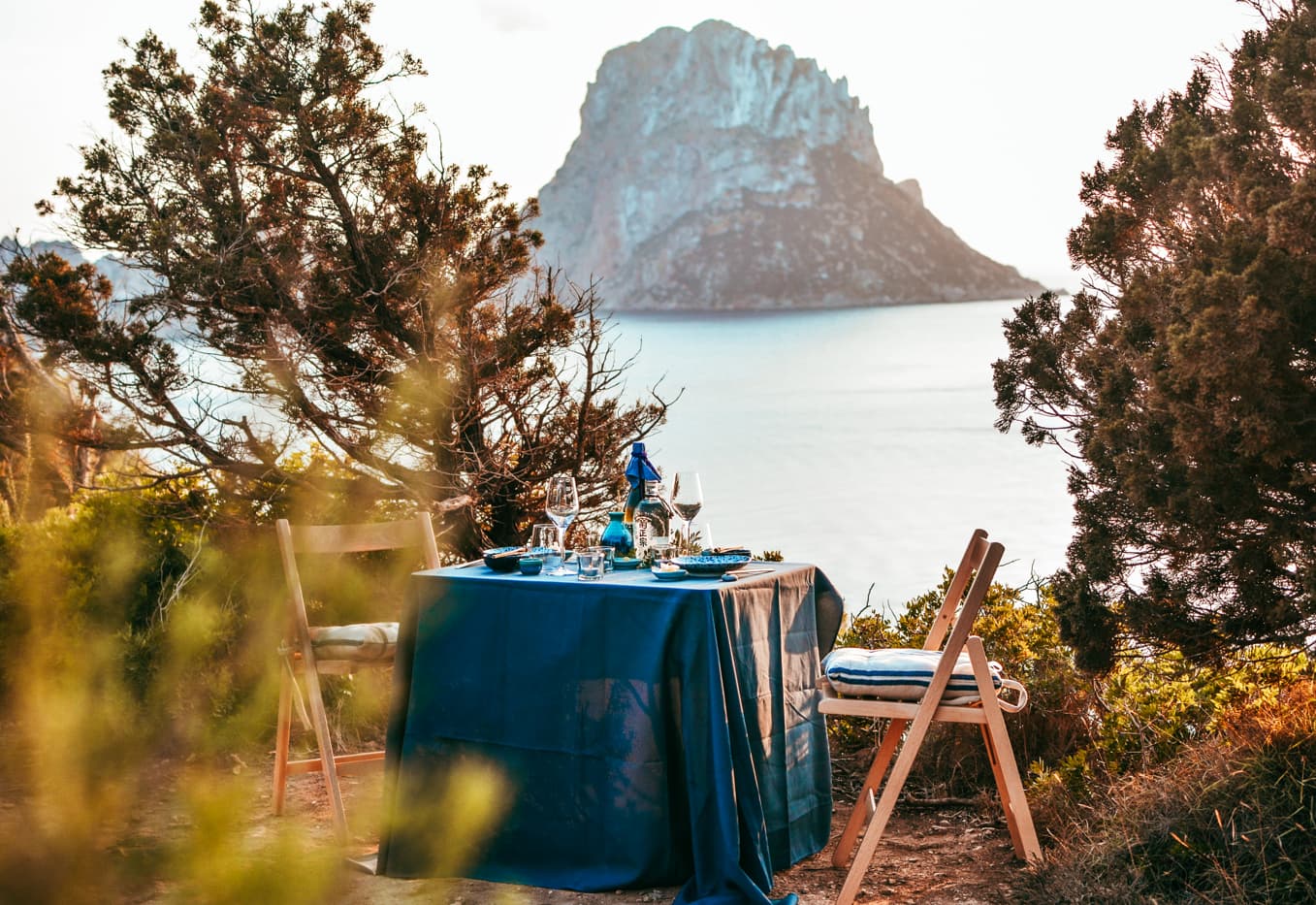 table is set up for a sushi dinner with tsuma Ibiza , es vedra on the background